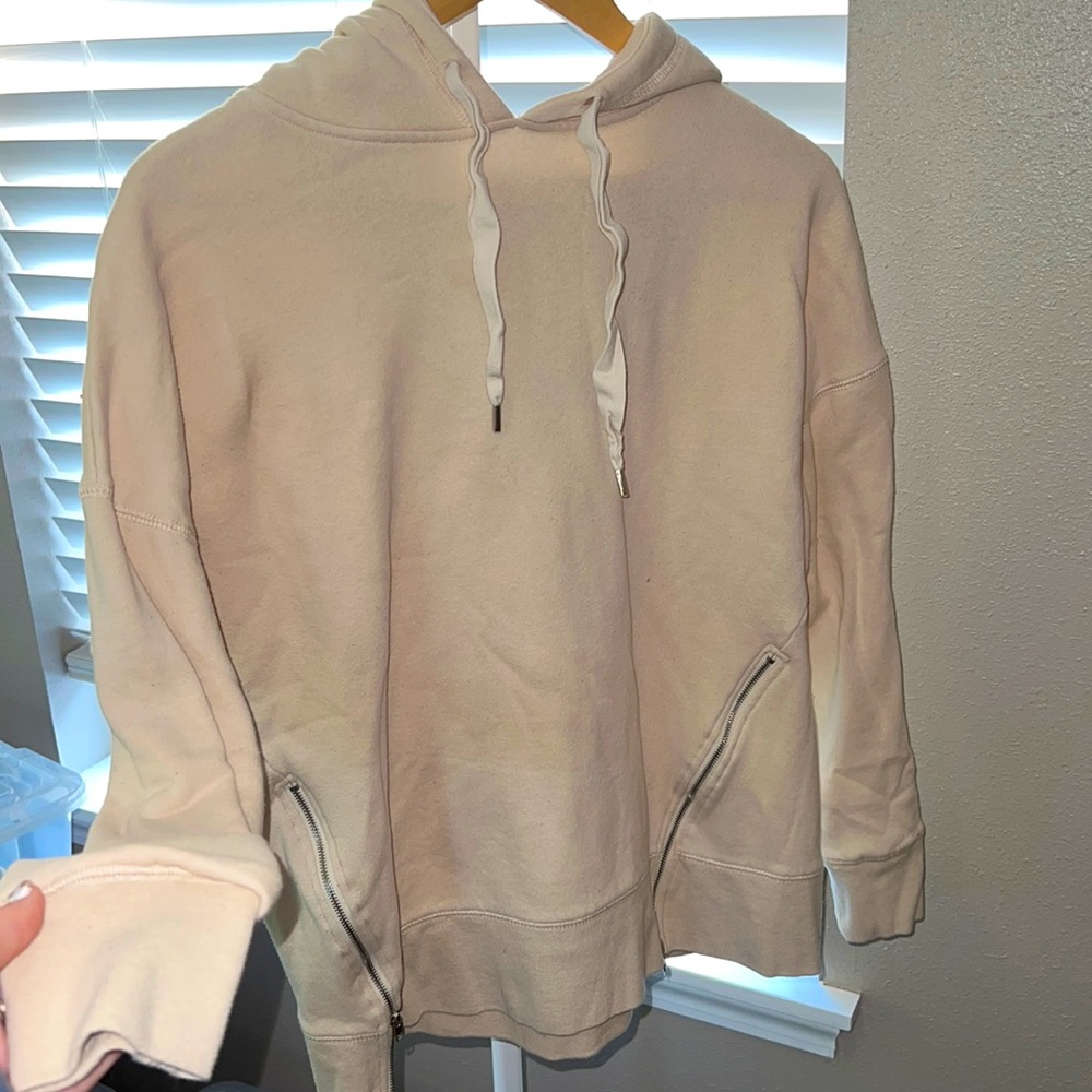 Cream hoodie w/ zippers.